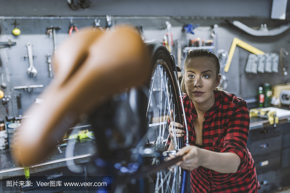 女自行车工程师正在车间里修理一辆自行车